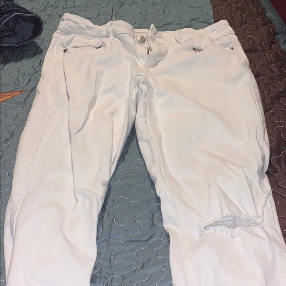 White jeans with a rip in the left knee